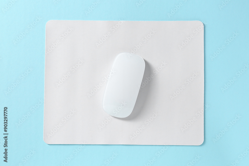 Wireless mouse and mousepad on light blue background, top view Wireless mouse and mousepad on light blue background, top view
