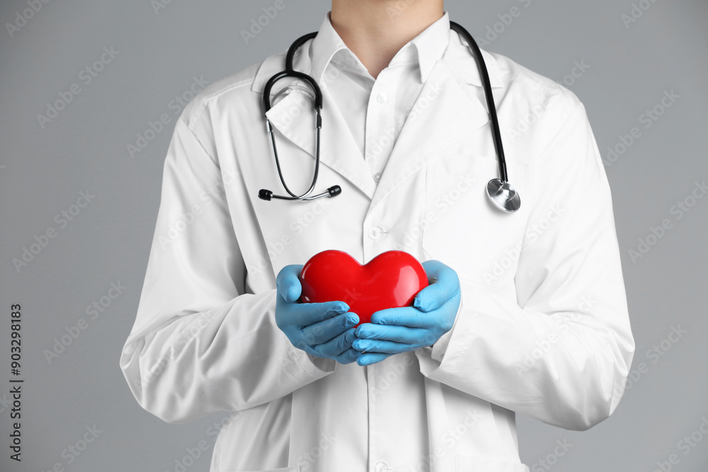 Doctor with red heart on grey background, closeup Doctor with red heart on grey background, closeup