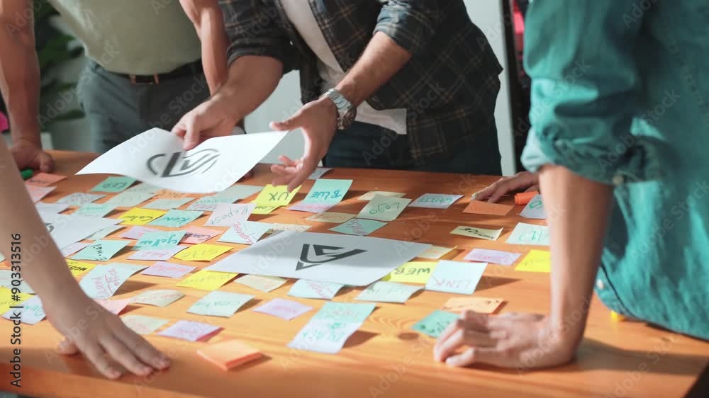 Close up of designer hands design logo graphic together at meeting. Professional graphic working together and brainstorming idea about product design at table with colorful sticky notes. Symposium. Close up of designer hands design logo graphic together at meeting. Professional graphic working together and brainstorming idea about product design at table with colorful sticky notes. Symposium.