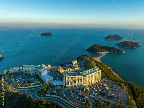 Chosa-ri, Jindo-gun, Jeollanam-do, South Korea - September 29, 2022: Aerial and summer view of parking lot and building of Jindo Sol Beach on the hill against Sosamdo Island on the sea
 photo