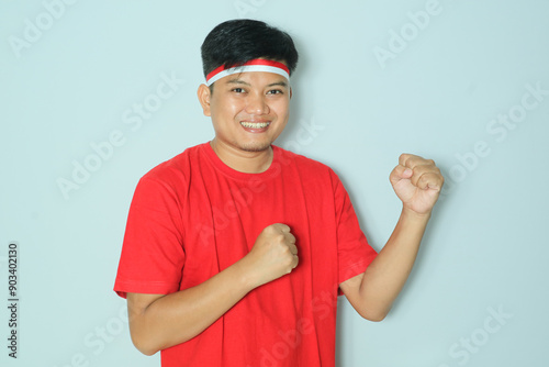 Indonesian men showing high spirits with their hands clenched during independence day celebrations. Wearing a red t-shirt photo