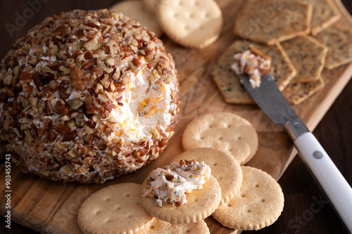 Close-up of a Classic Cheeseball with crackers on a cutting board with cheese knife