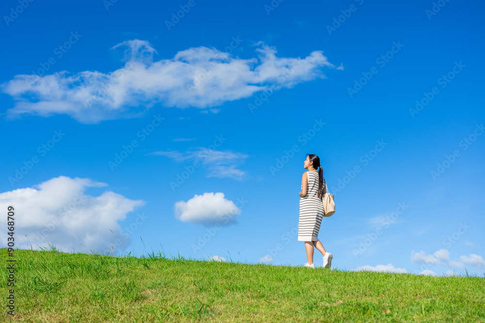 Pregnant woman cross over the park with blue sky Pregnant woman cross over the park with blue sky