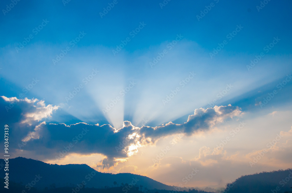 The sun's rays break through the blue clouds. The sun's rays break through the blue clouds.