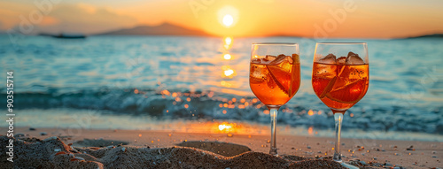 Two Aperol cocktails on the beach by the sea in the rays of the setting sun against a backdrop of sea waves and sand. With room for a text. Hello summer. photo