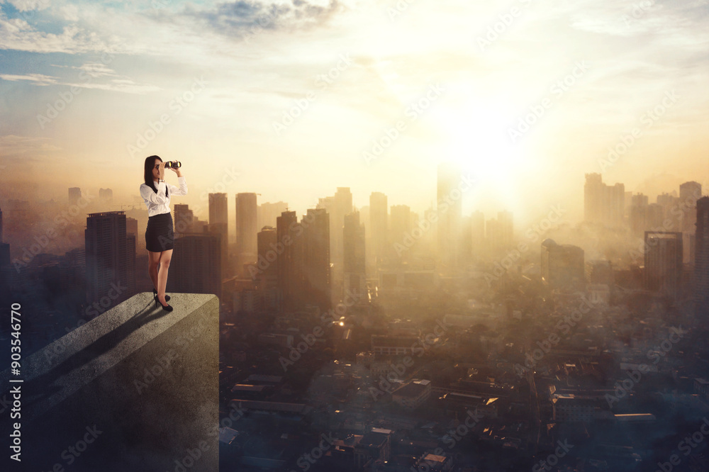 Businesswoman standing on a roof and looking at future city Businesswoman standing on a roof and looking at future city