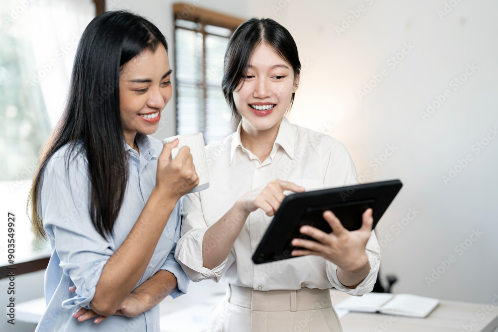 Business women standing next to a window and discussing their ideas. Business women standing next to a window and discussing their ideas.