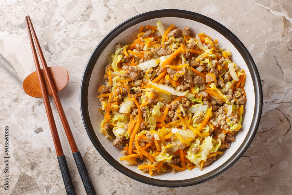 Eggroll in a bowl sauteed ground meat with vegetables in flavor packed sauce closeup on the table. Horizontal top view from above