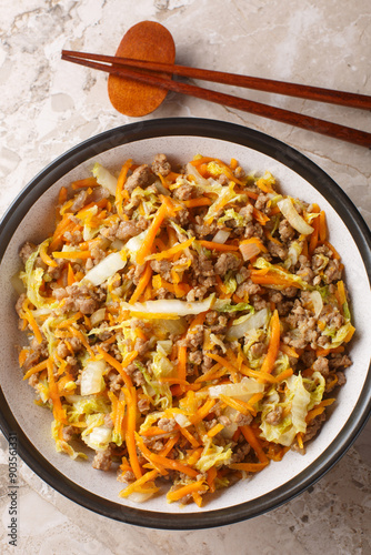 Obraz na płótnie Egg roll bowl with vegetables and meat traditional asian food in one pot close-up on table. Vertical top view from above w salonie