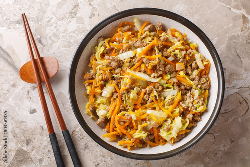 Obraz na płótnie Eggroll in a bowl sauteed ground meat with vegetables in flavor packed sauce closeup on the table. Horizontal top view from above w salonie