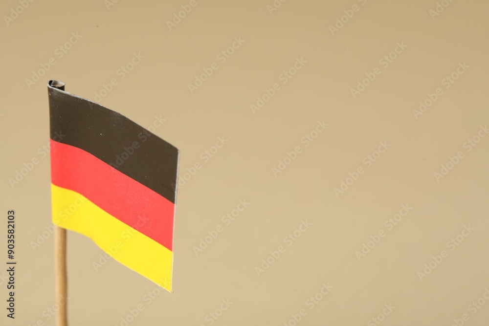 Small paper flag of Germany on beige background, closeup. Space for text Small paper flag of Germany on beige background, closeup. Space for text