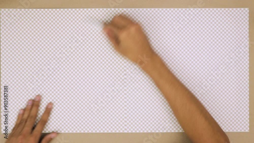 Hand smoothing a piece of checkered paper on a crafting table photo