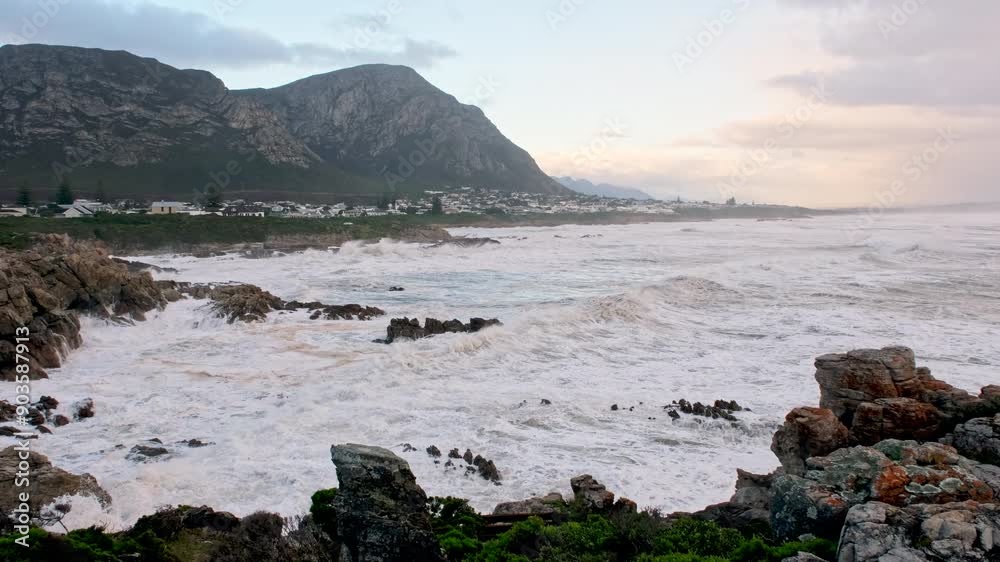 Turbulent waves crashing into rocky shore at Voëlklip Hermanus in winter storm Turbulent waves crashing into rocky shore at Voëlklip Hermanus in winter storm