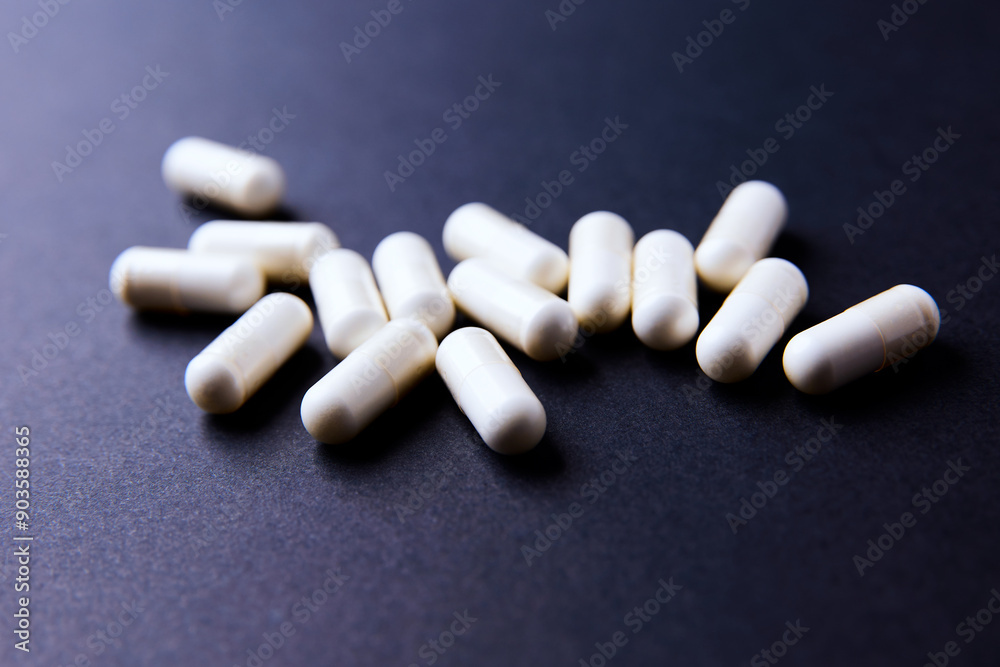 Creatine capsules on dark paper background. Soft focus. Copy space. Creatine capsules on dark paper background. Soft focus. Copy space.