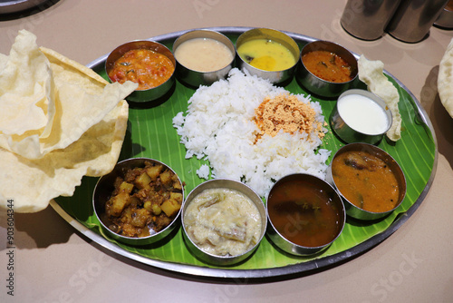 A South Indian thali or meal consists of steamed rice, sambar, rasam, vegetable curries, Avial, coconut chutney, pickles, papadum, curd or yogurt, and a sweet dish kheer. Ghee Podi masala.Sadya meal.