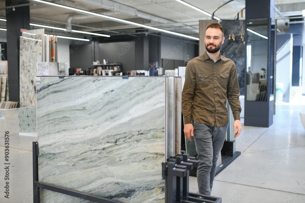 Fototapeta premium Man choosing tile among different samples in store