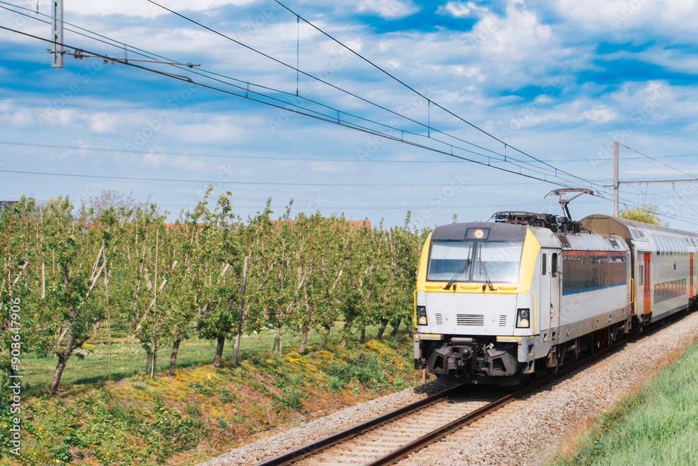 Electric train moving through fields in the countryside Electric train moving through fields in the countryside