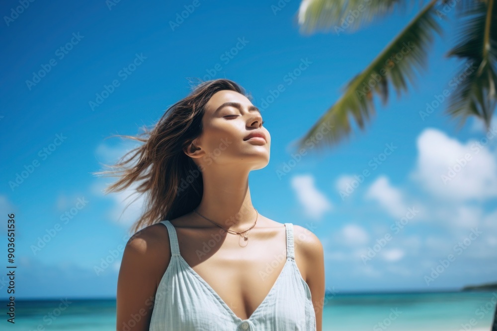 Young woman enjoying the warmth of the sun on a tropical beach. Relaxation and connection with nature. Summer and travel concept. Young woman enjoying the warmth of the sun on a tropical beach. Relaxation and connection with nature. Summer and travel concept.