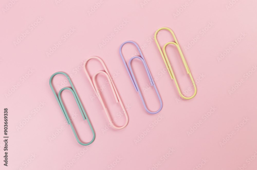 Top view of colorful paperclips on pink background. School, office wallpaper. Flat lay, copy space. Top view of colorful paperclips on pink background. School, office wallpaper. Flat lay, copy space.