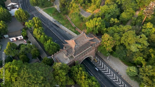 A stunning aerial shot of an ancient gate in Wuhan, juxtaposed with a modern road. The traditional architecture contrasts with the urban landscape, highlighting Wuhan's rich cultural heritage. photo