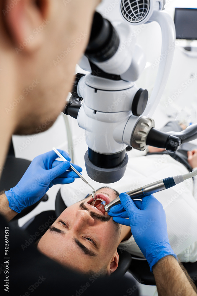 Dentist uses operating microscope to polish teeth of the patient. Operating dental digital microscope working process. Dentist uses operating microscope to polish teeth of the patient. Operating dental digital microscope working process.
