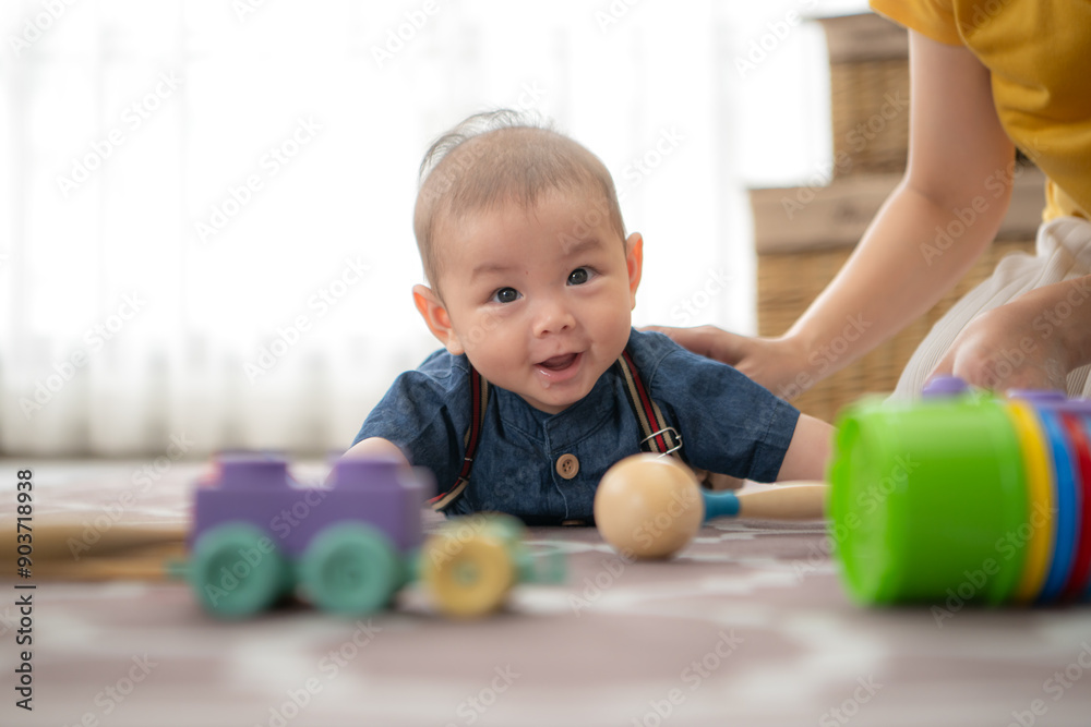 A tiny child cheerfully plays with toys on the floor of the living room with mom A tiny child cheerfully plays with toys on the floor of the living room with mom