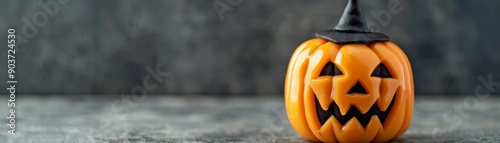 halloween jack-o-lantern pumpkin with witch hat on a grey background - festive autumn decor. photo