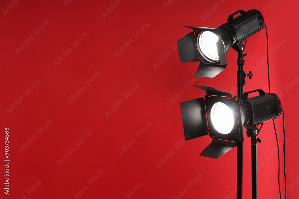 Red photo background and professional lighting equipment in studio, space for text Red photo background and professional lighting equipment in studio, space for text