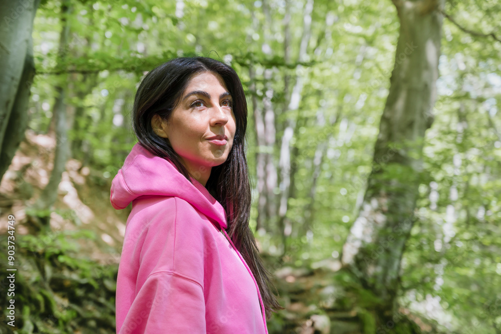 Young  woman standing in a green spring  forest