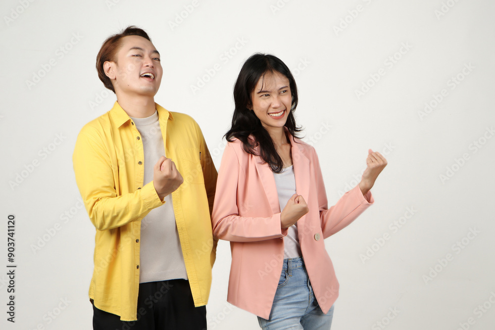 portrait of happy asian Indonesian couple raising arm with clenched fist on isolated background. portrait of happy asian Indonesian couple raising arm with clenched fist on isolated background.