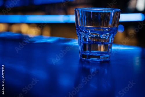 Tablou pe pânză A glass of water sits on a bar counter