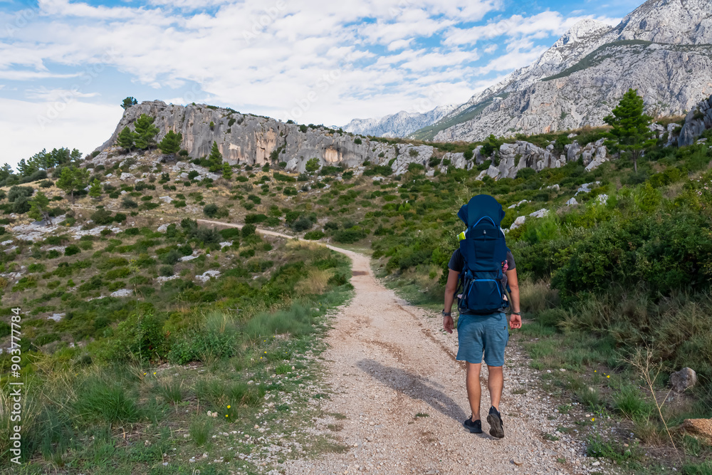 Φωτογραφία Hiker man with baby carrier backpack on idyllic hiking path to Tucepi town along Makarska Riviera, Dalmatia, Croatia, Europe