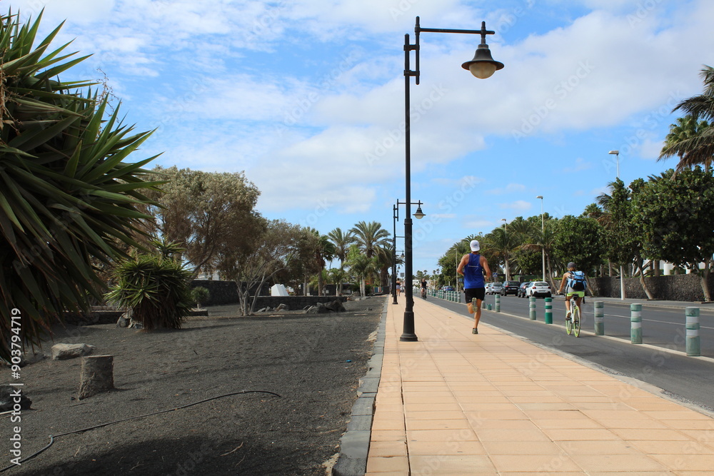 Obraz premium People Running on Alley Near Palm Trees