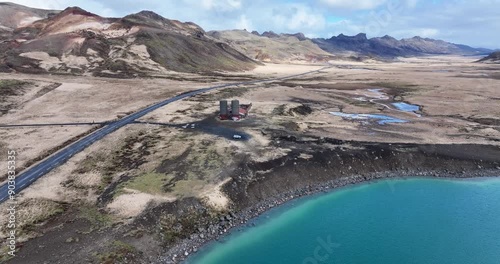 Breathtaking aerial view of an abandoned Iceland farm, perched on a hill overlooking a serene blue lake and winding road. photo