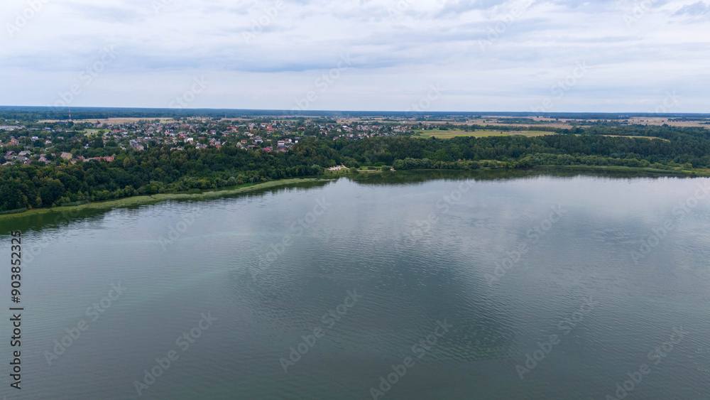 Drone photography of small town near lake surrounded by forest during summer day Drone photography of small town near lake surrounded by forest during summer day