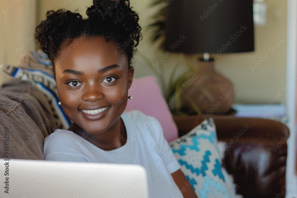 Fototapeta premium Smiling african american young woman studying online. Young female relaxing with laptop