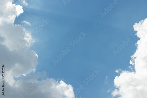Fototapeta Naklejka Na Ścianę i Meble -  White clouds in a blue sky with sunbeams breaking through them