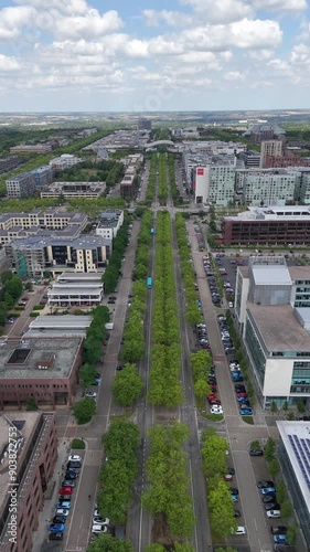 Overhead dolly shot of Midsummer Boulevard with buses driving up towards an intersection, Midsummer Place, Christ the Cornerstone Church and Xscape in the background