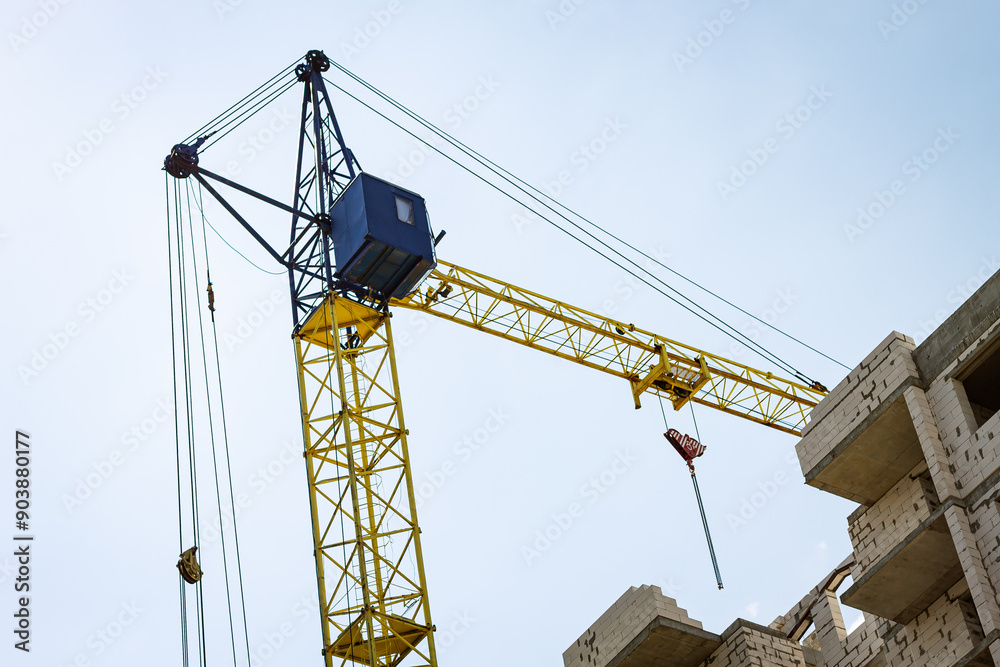 A tower crane at a house construction site. A tower crane at a house construction site.