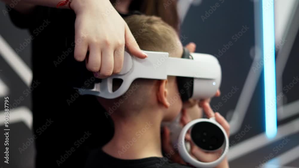The instructor puts a virtual reality helmet on the boy's player. Preparing for the tournament in the VR space. The instructor puts a virtual reality helmet on the boy's player. Preparing for the tournament in the VR space.