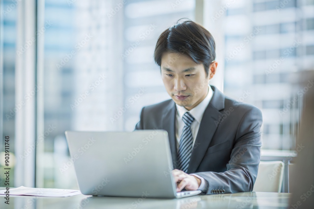 ノートパソコンで保険データを分析する日本人実業家
ノートパソコンで保険データを分析する日本人実業家