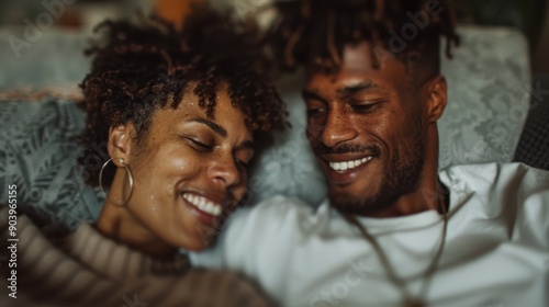 A warm, close-up image of a couple lying on a sofa, laughing and smiling together, conveying an intimate moment of love and connection, captured in cozy ambiance.