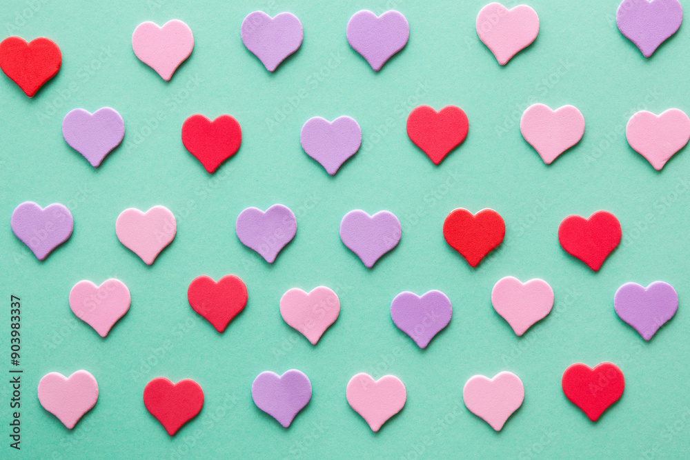 Pink and purple hearts on mint green color as a background for love and relationship concept design Pink and purple hearts on mint green color as a background for love and relationship concept design