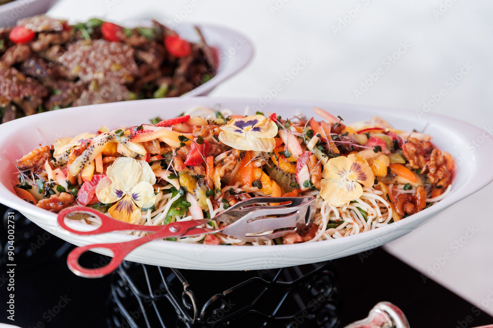 Colorful Mixed Salad with Edible Flowers and Nuts on a White Serving Platter