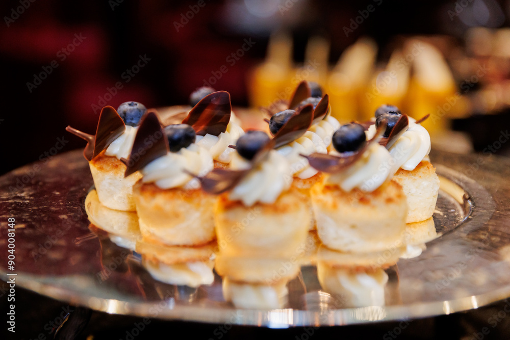 Delicious Mini Pancake Bites with Cream, Blueberries, and Chocolate on a Plate