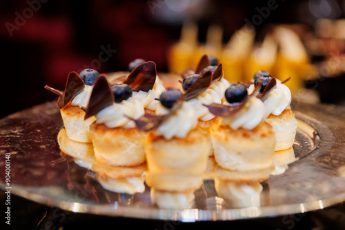 Delicious Mini Pancake Bites with Cream, Blueberries, and Chocolate on a Plate