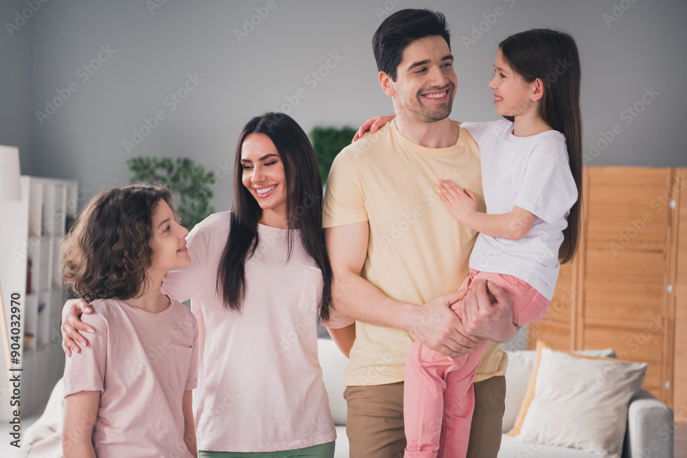 Photo of positive good mood parents children dressed casual clothes smiling embracing indoors house apartment room Photo of positive good mood parents children dressed casual clothes smiling embracing indoors house apartment room