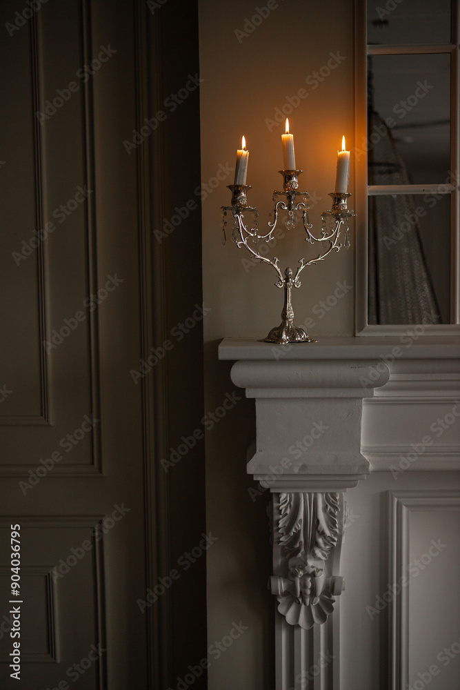 a silver candelabra with a white candles on top of it in a room a silver candelabra with a white candles on top of it in a room