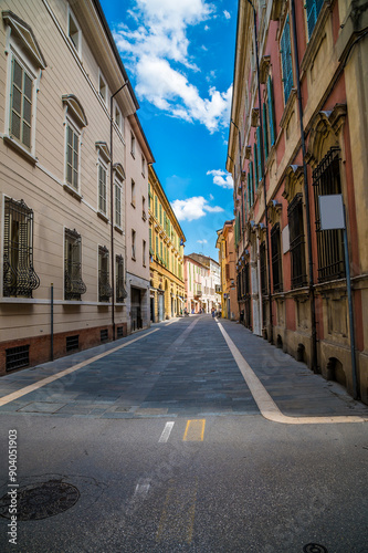 A view down a quiet street with colourful buildings in Faenza, Italy in summertime