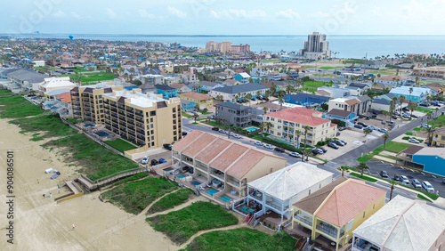 Beach condos, hotel with swimming pool, boardwalk access to sandy shoreline tropical South Beach, South Padre Island, exquisite barrier Gulf Coast of Texas, people enjoy beach activities aerial photo